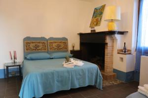 纳尔尼Agriturismo Madre Terra的一间卧室设有一张蓝色的床和壁炉