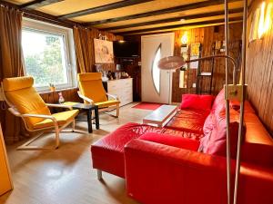 欧布特森Bijouswiss " Yellow House"的客厅配有红色沙发和黄色椅子