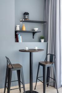 迪拜Silkhaus comfy furnished studio in the heart of DIFC的一张桌子和两张椅子以及一张桌子和架子