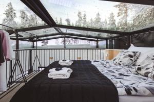 锡尔卡Glass Ceiling Suite Kipinä的一间卧室配有带毛巾的床