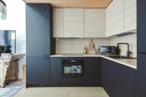 锡尔卡Glass Ceiling Suite Kipinä的厨房配有黑色橱柜和蓝色的墙壁