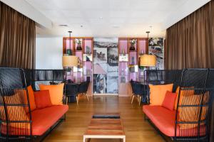 恩波其克Noga by Isrotel Collection - The Renewed Ganim Hotel的一间设有橙色椅子和桌子的餐厅