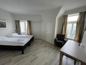 奥斯陆P酒店的配有一张床和一把椅子的酒店客房