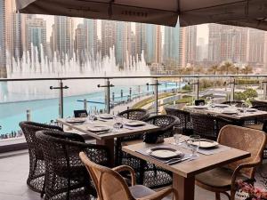 迪拜Silkhaus Burj Khalifa view large 2BDR in new tower的一间带桌椅的餐厅和一个喷泉