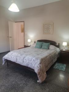 杜拉斯诺MANDALA HOME的一间卧室配有一张大床、两张桌子和两盏灯。