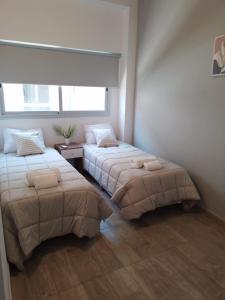 门多萨356 Apartments -的一间卧室设有两张床和窗户。