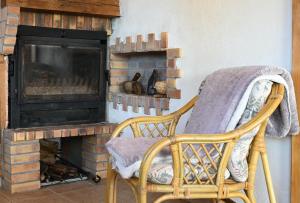 圣吉隆Maisonnette à la campagne Ariège的壁炉前的藤椅