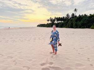 坦加拉Shine Wave Turtle Beach的女人站在海滩上
