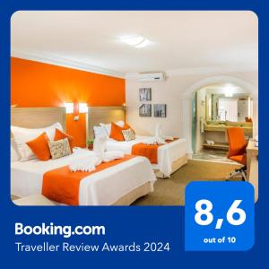 伊拉普阿托Hotel Flamingo Irapuato的橙色墙壁的酒店客房内的两张床