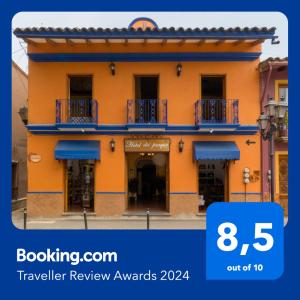 NaolincoHotel del Parque Naolinco的黄色的建筑,街道上设有蓝色的阳台