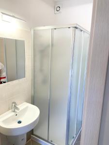 西尔米奥奈Sirmione Rosselli Apartments的带淋浴和盥洗盆的浴室