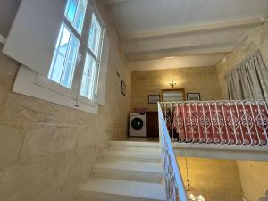 ŻejtunB&S Accommodation 1940 House of Character的楼梯,楼梯,有窗户和楼梯栏杆的房子
