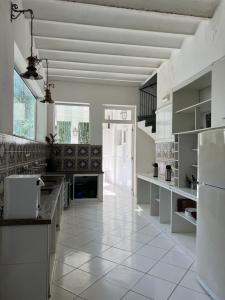 里约热内卢Castelo dos Tucanos Hostel的厨房铺有白色瓷砖地板,配有白色冰箱。