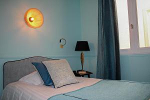 蒙彼利埃宫殿酒店的一间卧室配有一张带灯和窗户的床