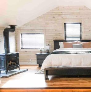 埃洛拉Etherington Suites的一间卧室配有一张床和一个燃木炉子