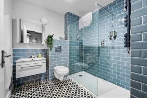 赛伦塞斯特2 bedroom apartment in the Town centre with free private parking的蓝色瓷砖浴室设有卫生间和淋浴。