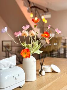 春蓬Willow Pillow Guest House & Poshtel的一张桌子上花的白色花瓶