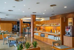 平托西班牙平托波萨达斯酒店的一间带桌椅的餐厅和一间自助餐厅