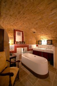贝尔韦Logis Hôtel Le Boudoir的大型浴室设有大浴缸和水槽