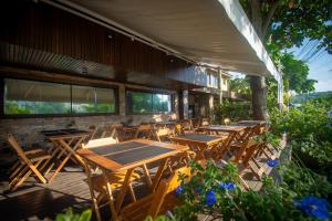 布希奥斯Hotel Barra da Lagoa by Latitud Hoteles的庭院里摆放着几张木桌和椅子