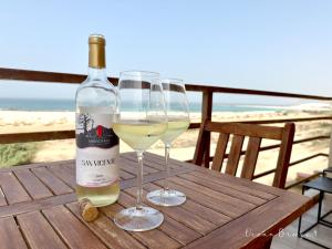 萨尔雷Ocean Breeze 9的木桌旁放两杯白葡萄酒