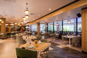 拉各斯Eko Hotel Gardens的餐厅设有桌椅和窗户。