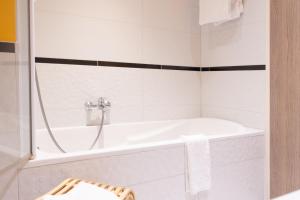 福尔巴克水星佛巴驰中央酒店的白色的浴室设有浴缸和水槽。