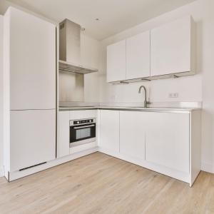 克劳利Crawley Apartment near Gatwick Manor Royal Newly Refurbished Sleeps 4的一间空厨房,配有白色橱柜和水槽