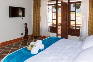 莱瓦镇HOTEL ENCANTO COLONIAL的一间卧室配有带毛巾的床