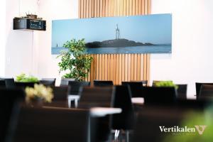 利勒桑Vertikalen的一张投影屏幕,放在带桌椅的房间
