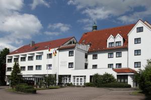兰格瑙维斯瑟斯洛斯鲁宾格酒店的一座白色的大建筑,有红色的屋顶