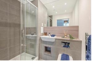 达格纳姆UPPAMOST luxury home 3的一间带水槽和玻璃淋浴的浴室