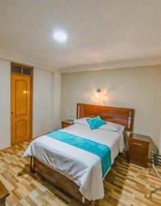 莫克瓜Hotel Loyalty Moquegua的一间卧室设有一张大床,铺有木地板