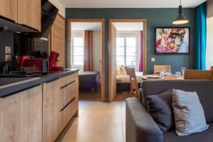 安锡OURAL Annecy Rent Lodge的厨房以及带沙发和桌子的客厅。