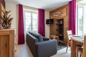 安锡CARPATES Annecy Rent Lodge的客厅配有红色窗帘和沙发