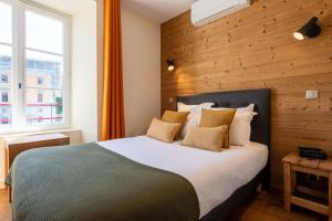 安锡CARPATES Annecy Rent Lodge的一间卧室设有一张带木墙的大床