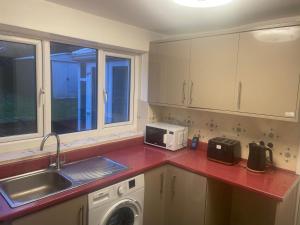 伯明翰4 Bed Comfy House in Birmingham的厨房配有水槽和洗衣机