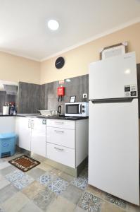 塞图巴尔Suites DP Setúbal的厨房配有白色橱柜和冰箱。
