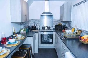 达德利Luxurious 5-Beds House in Dudley的厨房配有白色橱柜和炉灶烤箱。