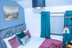 达德利Luxurious 5-Beds House in Dudley的一间卧室配有一张蓝色墙壁的床