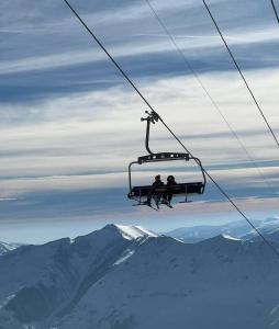 古多里Premium Mountain Apartment Close The Gondola lift的两人骑着山地滑雪缆车