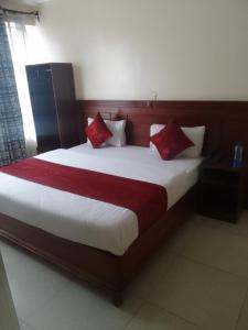 ThikaDeka hotel Nairobi的一间卧室配有一张带红色枕头的大床