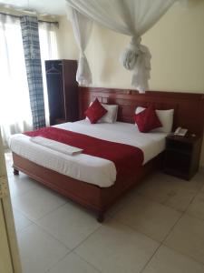 ThikaDeka hotel Nairobi的一间卧室配有一张带红色枕头的大床