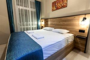 博卢Bolu Deluxe Otel的卧室配有一张带白色床单和枕头的大床。