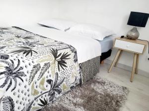摩兰吉斯Studio cosy proche Paris Orly的一间卧室配有一张带黑白色床罩的床。