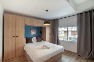 昂蒂布Charmant Appartement Antibes的一间卧室设有一张大床和大窗户