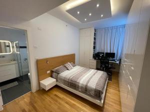 内坦亚Netanya Dream Luxury Apartment MIGDAL DAVID的一间卧室配有一张床和一张书桌