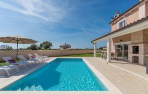 罗波里卡Villa Magica的房屋旁的游泳池配有椅子和遮阳伞