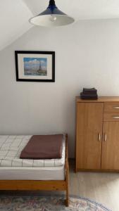 GnjilaneVilla Pluto的一间卧室配有一张床和一个木制橱柜