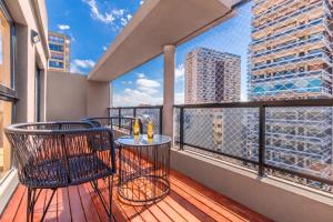 布宜诺斯艾利斯Modern Apartments in Palermo的阳台配有桌椅,享有城市美景。